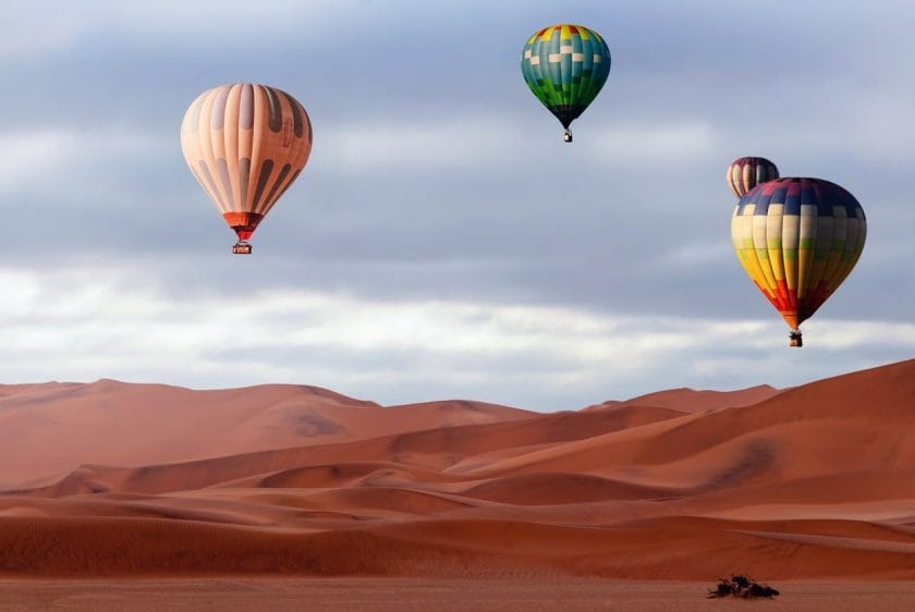 Beautiful Colorful Hot Air Baloons and dramatic clouds over the sand dunes in the Namib desert